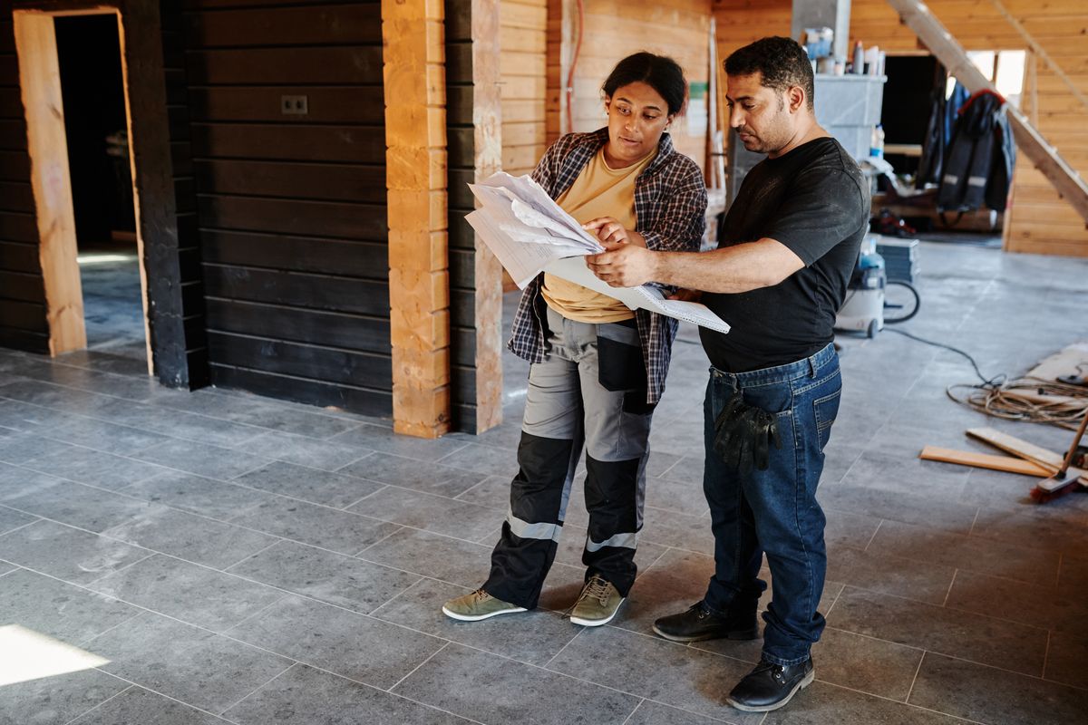 Handwerker besprechen ein Bauprojekt auf einer Baustelle (Symbolbild)
